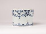 blue and white vase sitting on a white surface with a light gray background
