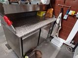 un chien qui se tient dans la cuisine et regarde l'évier