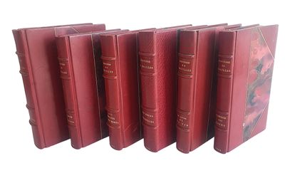 six livres rouges alignés sur une surface blanche