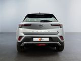 the rear end of a silver car in a white room