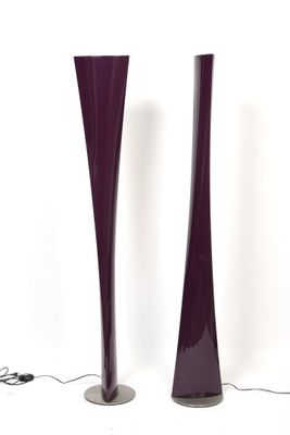 pair of tall purple glass vases sitting next to each other on a white surface