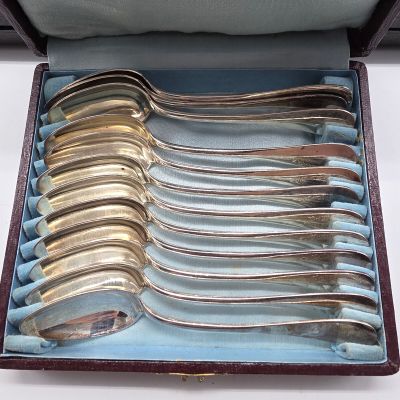 six cuillères posées dans un étui sur une table