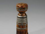 une image représentant un vase en bois et en métal posé sur une surface blanche
