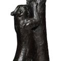 statue of a dog holding a human ' s hand on a white background