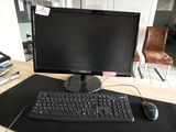 un écran d'ordinateur et un clavier posés sur un bureau, avec une souris