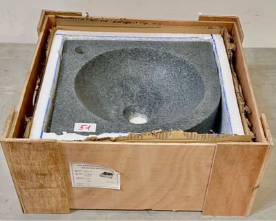 une caisse posée par terre, avec un lavabo à l'intérieur