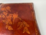 a brown leather book with a floral design on it