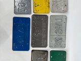 six different colored license plates are arranged on a white surface