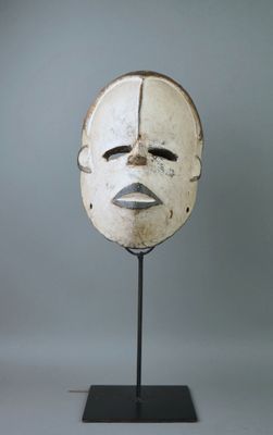 une image représentant un masque blanc posé sur un socle noir