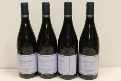 trois bouteilles de vin sont alignées sur une table