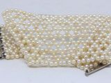 bracelet with white pearls and a silver clasp on a white background