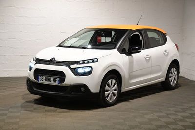 La petite voiture blanche est garée dans le garage.