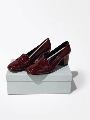 a pair of red shoes sitting on top of a white box