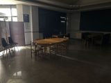 des tables et des chaises dans une pièce, avec un tableau noir en arrière-plan