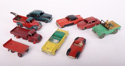 several toy cars are lined up in a row on a white surface