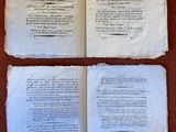 deux pages d'un livre posées sur une table, avec un stylo et du papier