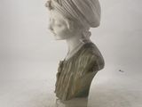 a white marble bust of a woman with a turban on her head