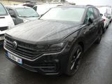 Le SUV Volkswagen noir est garé sur un parking, à côté d'autres voitures.