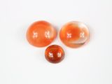 trois billes orange et blanches sur une surface blanche