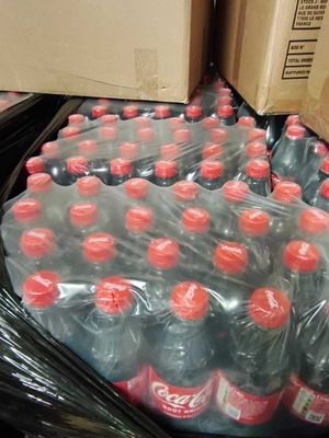 de nombreuses bouteilles de soda posées sur un tapis roulant