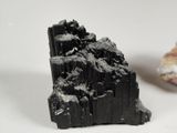 a piece of black rock next to a piece of black rock on a white surface