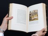 a person holding an open book with a picture on it