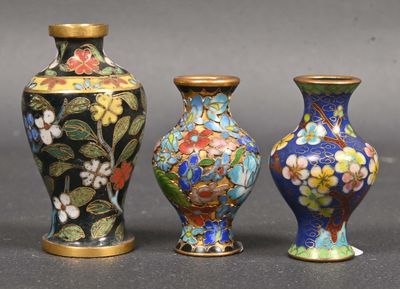 three vases sitting side by side on a table with a gray background