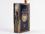 a black and gold book with a golden cover sitting on top of a table