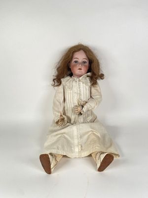 une image représentant une poupée assise sur une surface blanche, vêtue d'une robe blanche et de chaussures marron