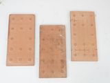 three pieces of wood with holes on them sitting on a table