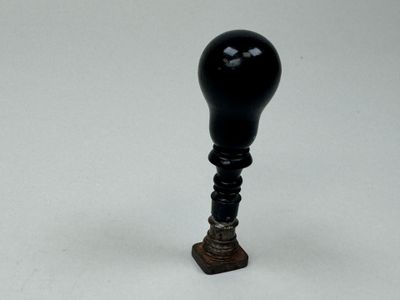 un gros plan d'un petit objet noir sur une surface blanche