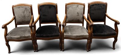four chairs with black velvet upholstered seats and a wooden frame
