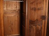 a wooden armoire with a door open in a room