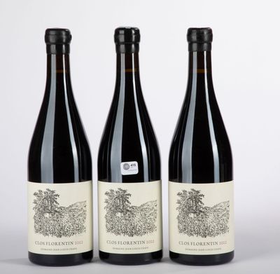 trois bouteilles de vin posées l'une à côté de l'autre sur une table