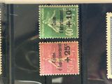 four different colored stamps are on display in a glass case