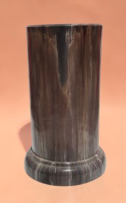 an image of a black marble vase on a pink background