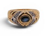 a close up of a gold ring with a blue stone