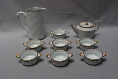 de nombreuses tasses et un pichet posés sur une table