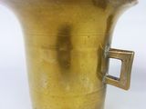 a brass cup with a handle on a white background