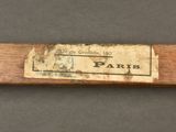 an old baseball bat with a label on it sitting on a table