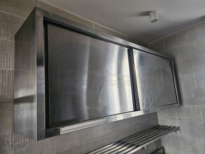 une armoire murale en acier inoxydable dans une salle de bains