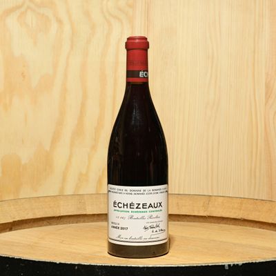 a bottle of wine sitting on top of a barrel