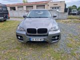 the bmw x5 is parked in front of a building