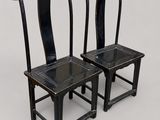 pair of black chairs on a white surface with a white background