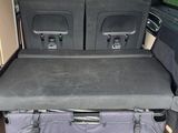 two seats in the back of a van with luggage in the trunk