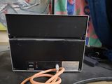 a black box sitting on a table next to a pair of orange hoses