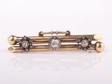 a close up of a gold and diamond bracelet on a white surface