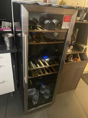 une cave à vin contenant de nombreuses bouteilles, dans la cuisine