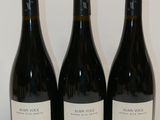 three bottles of wine are lined up on a table
