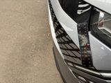 a close up of a car ' s headlight with a measuring tape on it
